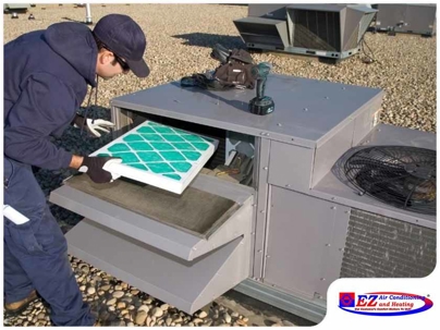 HVAC technician replacing an air filter in a rooftop HVAC unit