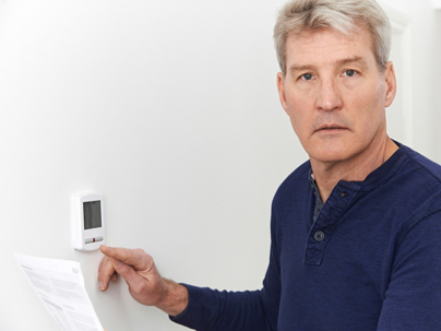a man chekcing the thermostat