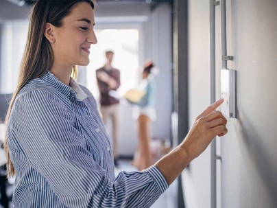 a woman checking their thermostat