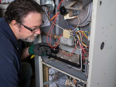 a technician checking the gas furnace