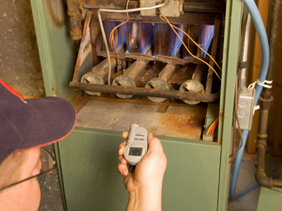 a technician inspecting a gas furnace