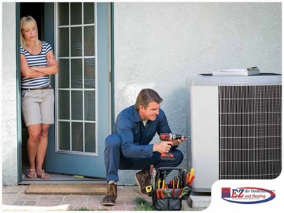 HVAC technician working on a central air conditioning condenser unit