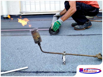 roofing professional installing a torch-down roofing membrane