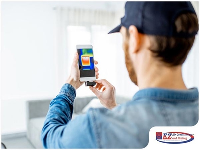 technician using a thermal imaging camera attached to a smartphone