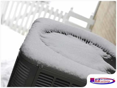 outdoor HVAC unit (likely a heat pump or air conditioner) covered in snow