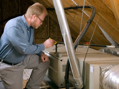 a technician inspecting a furnace or an air handler, likely performing maintenance or a repair.